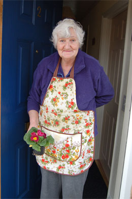 lady at her front door holding flowers